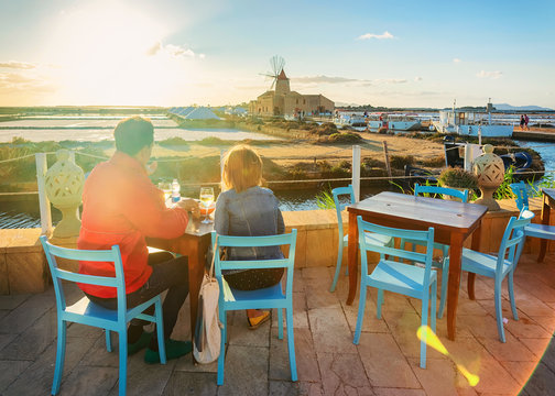People at street restaurant at salt evaporation pond Marsala Sicily