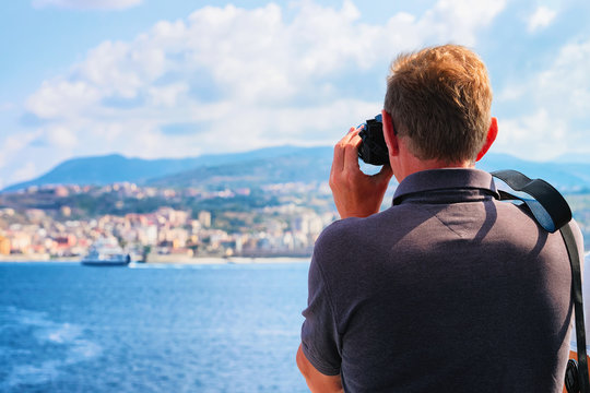 Man taking photos of Mediterranean Sea and landscape Reggio Calabria