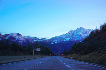 Road with view of Alpine mountains in Austria at evening