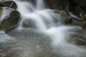 view of a stream flowing down from stickle tarn in langdale in the lake district national park in the north of england showing the blurred water moving down over dark rock