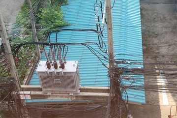 Unstable power lines on power poles with large transformers in the city.