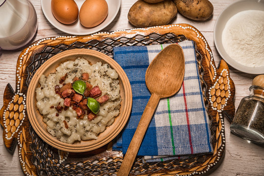 Slovak traditional dishes, potato gnocchi, bryndza, on wooden pancakes, potatoes, eggs. milk, sheep's cheese