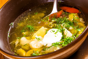 Soup with different vegetables and sour cream. Close-up