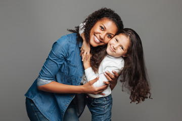 Cheerful mother embracing her smiling daughter