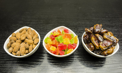 Bowls with additions to cakes and desserts: dried dates, candied pineapple and shelled almonds.
