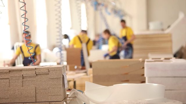 Furniture factory workers in yellow overalls collect furniture, Furniture manufacture,, industrial interior,small depth of field