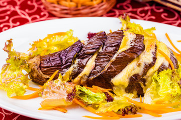 Eggplant baked with cheese on white plate. Close-up