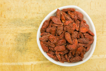 Dried goji berries on a wooden board. View from above.