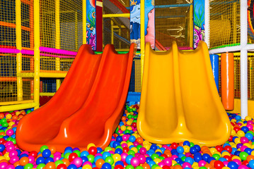 large children's playroom with a slide and colorful balls in entertainment center