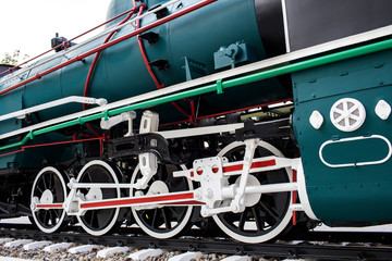 An old steam locomotive in black and green color is shown in the park for people to take a look. 