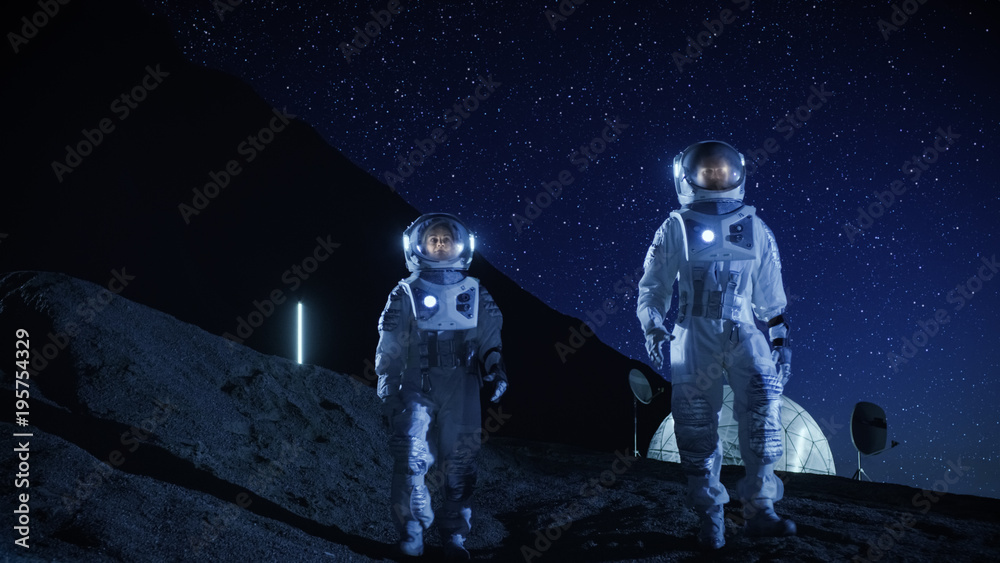 Canvas Prints two astronauts in space suits exploring newly discovered planet. in the background space base. night