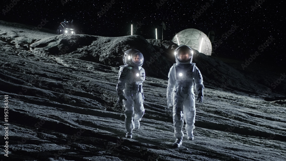 Wall mural two astronauts in space suits walk on the alien planet looking at the sky. in the background base wi