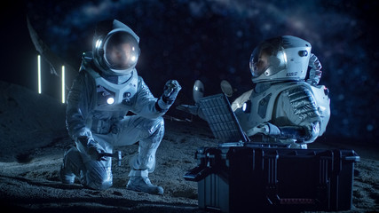 Two Astronauts Collect Rock and Soil Samples on the Alien Planet. Space Travel and Exploration, Finding Habitable Planet, Colonization Concept. © Gorodenkoff