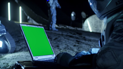 Astronaut on the Alien Planet Works on a Mock-up Green Screen Laptop. In the Background Her Crew...