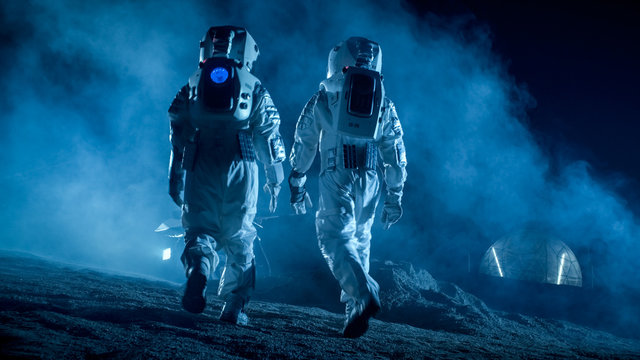 Shot of Two Astronauts in Space Suits on Alien Planet Walking Toward Rover and Geodesic Dome. High-Tech Space Exploration Concept. Manned Mission Searching and Discovering New Habitable Planets.