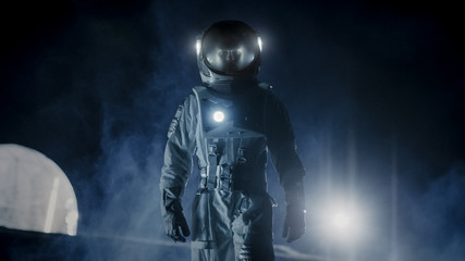Fototapeta na wymiar Courageous Astronaut in the Space Suit with Flashlight Explores Mysterious Alien Planet Covered in Mist. Adventure. Space Travel, Habitable World and Colonization Concept.