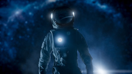 Courageous Astronaut in the Space Suit with Flashlight Explores Mysterious Alien Planet. The Milky Way Galaxy in Background. Adventure. Space Travel, Habitable World and Colonization Concept. - obrazy, fototapety, plakaty