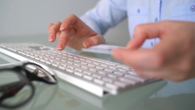 Woman pays by credit card purchases on the Internet. Woman office worker typing on the keyboard. Online payment concept
