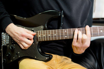 Obraz na płótnie Canvas Guy plays guitar close up.