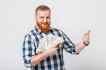 man with beard holding lot of hundred-dollar bills