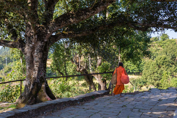 Nepali aged pilgrim in orange robe