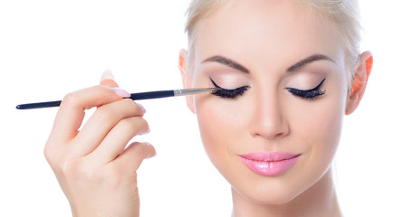 Fototapeta premium Junge Frau beim Auftragen von Make-up, Kosmetik, Schönheit, Beauty, Makeup, Gesicht; Nahaufnahme