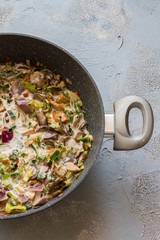 Trofie pasta with muschrooms leek and creme fraiche. Pan on blue and gray background. 