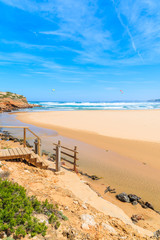 Fototapeta na wymiar Wooden walkway to beautiful Praia da Bordeira beach, popular place to do kite surfing, Algarve, Portugal