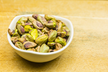 Bowl with shelled, roasted pistachios.