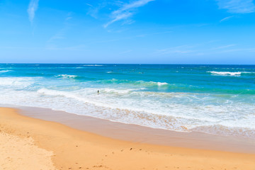 Fototapeta na wymiar A view of sandy Praia do Amado beach and sea with waves, Portugal