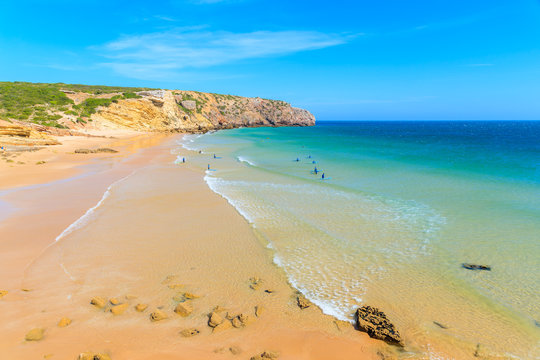 People surfing on beautiful Zavial beach on sunny beautiful day, Algarve, Portugal