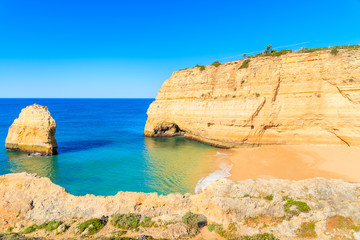 Fototapeta premium A view of secluded beautiful beach and cliffs on coast of Portugal near Carvoeiro town