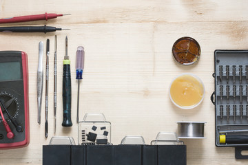 Repairman workplace with phone and special tools. Tool set: multimeter, magnifying glass, soldering...