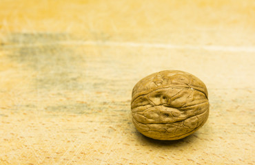 Whole walnut on a wooden background.