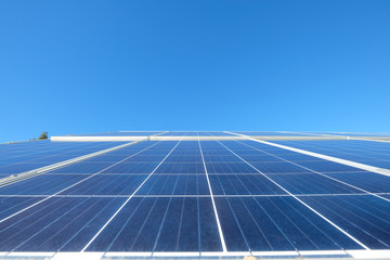 Solar panels with photovoltaic  modules for renewable energy with blue sky and mountains in the back round set in a countryside meadow 