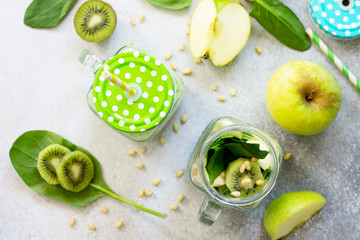 Green smoothies and apple, kiwi, spinach, pine nuts. Proper nutrition. Top view flat lay background.