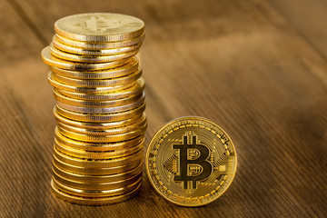 Single gold Bitcoin coin alongside a pile