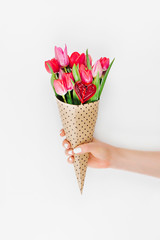 Female hands holding a bouquet of tulips wrapped in paper