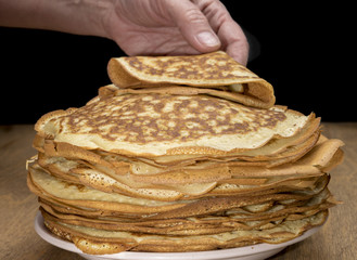 Pancakes in a plate on a wooden table