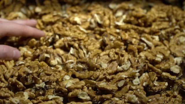 A woman's hand touches walnuts