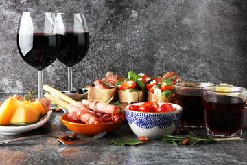 Italian antipasti wine snacks set. Cheese variety, Mediterranean olives, pickles, Prosciutto di Parma, tomatoes, artichokes and wine in glasses