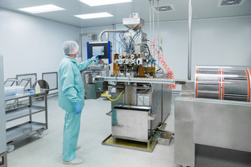 Pharmacy industry factory man worker in protective clothing in sterile working conditions