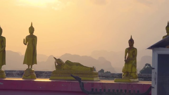 Golden Buddha statuettes at sunset on the top of Tiger Cave Temple in Krabi, Thailand