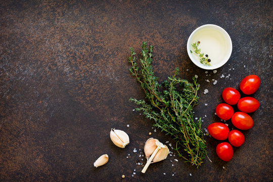 Food background. Thyme, garlic, cherry tomato and olive oil. Copy space, top view flat lay background.