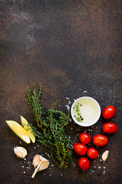 Food background. Thyme, garlic, cherry tomato, olive oil and lemon. Copy space, top view flat lay background.
