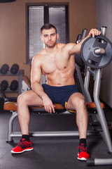 Fototapeta premium Brutal athletic man pumping up muscles on bench press