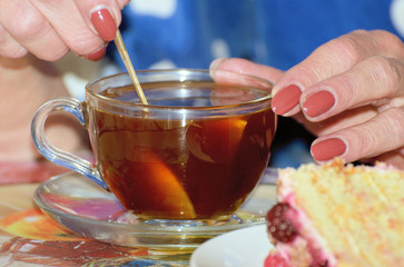 In a Cup of tea, a woman kneads sugar.