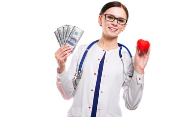 Young beautiful female doctor holding heart and money in her hands on white background