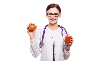 Female nutritionist hold tomato in section and glass of juice in her hands on white background