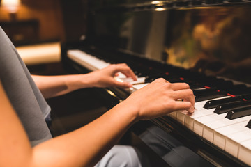 Asian woman hand playing keyboard of a piano in romantic atmosphere. Music instrument, solo...